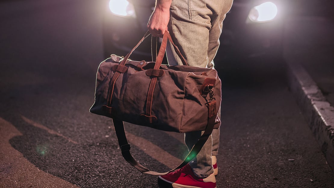 Man holding a brown canvas bag